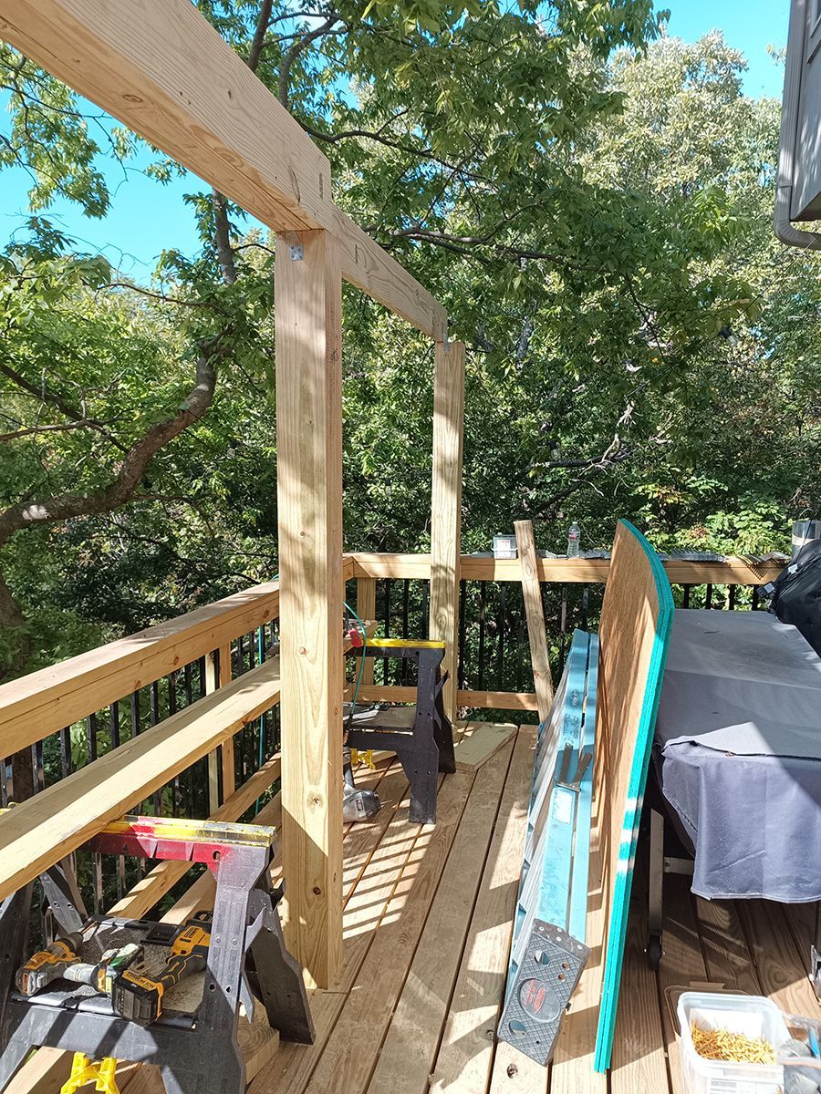 A wooden deck is being built with trees in the background.