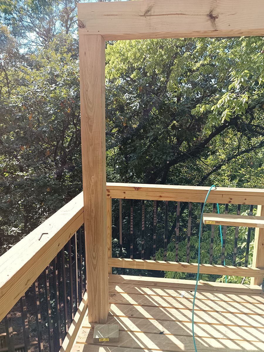 A wooden deck with trees in the background is being built.