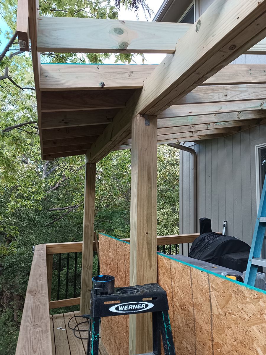 A wooden deck is being built on top of a house.