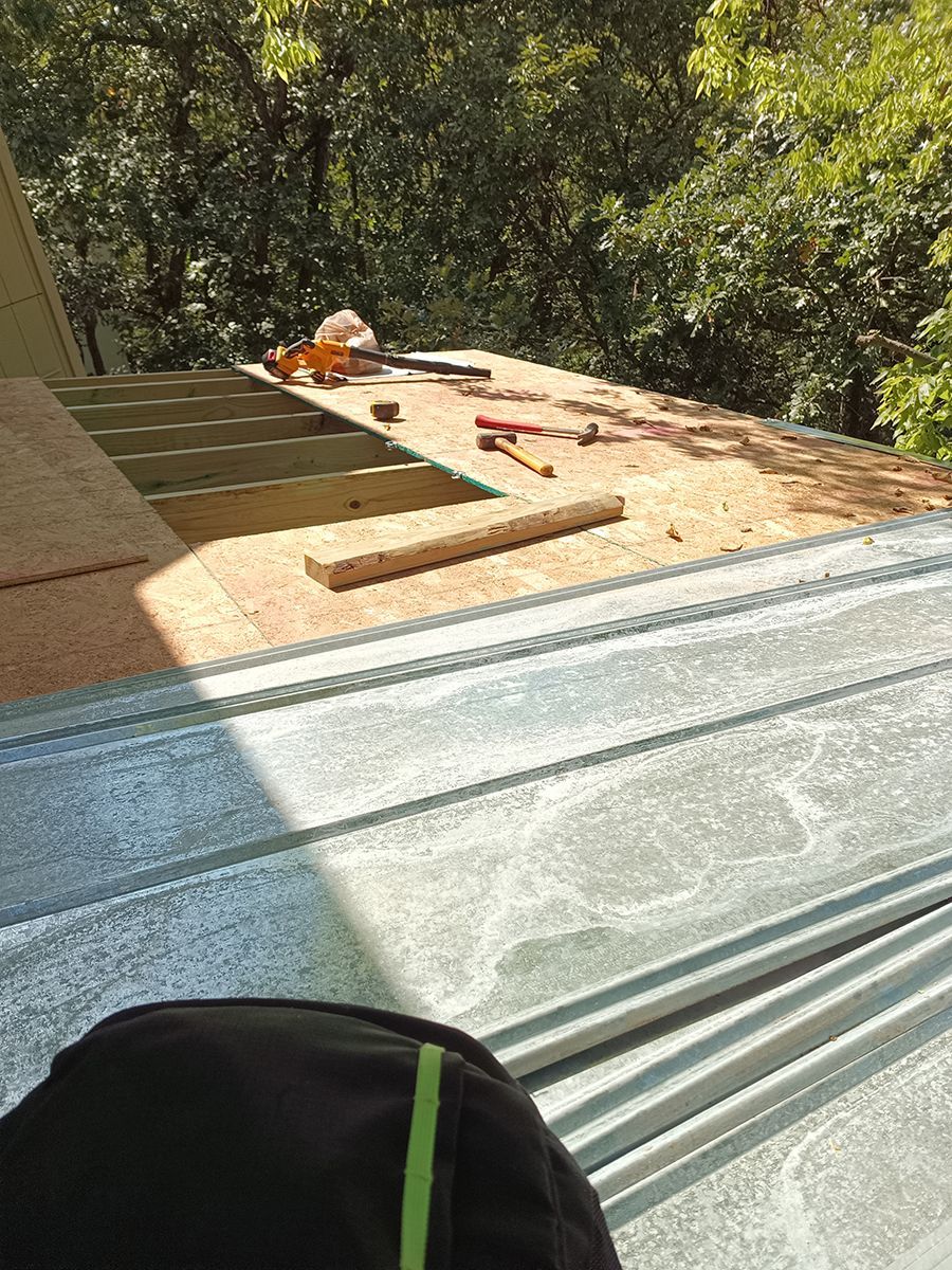 A person is sitting on the roof of a building.