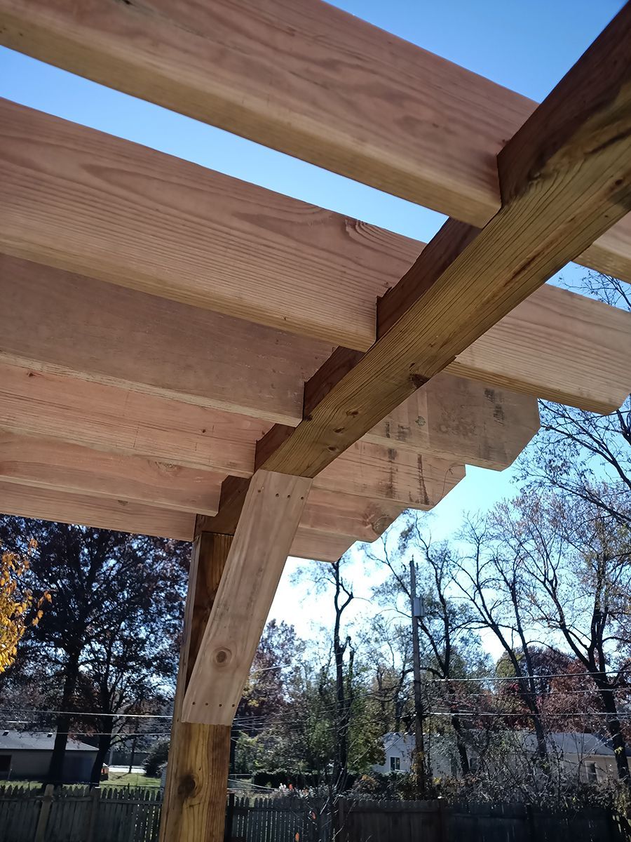 A close up of a wooden structure with trees in the background.