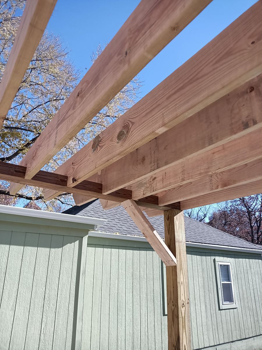 A wooden structure is being built in front of a house.