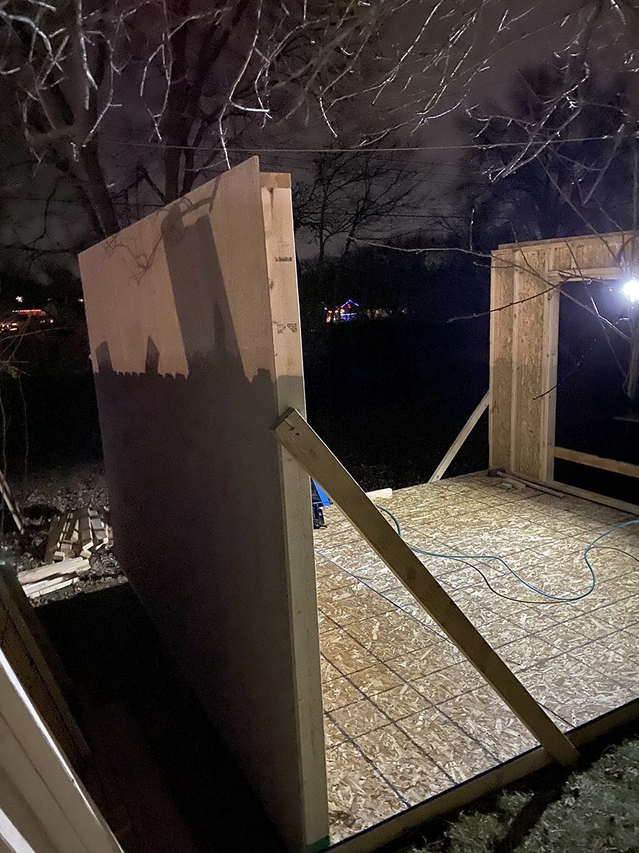 A wooden structure is being built at night.