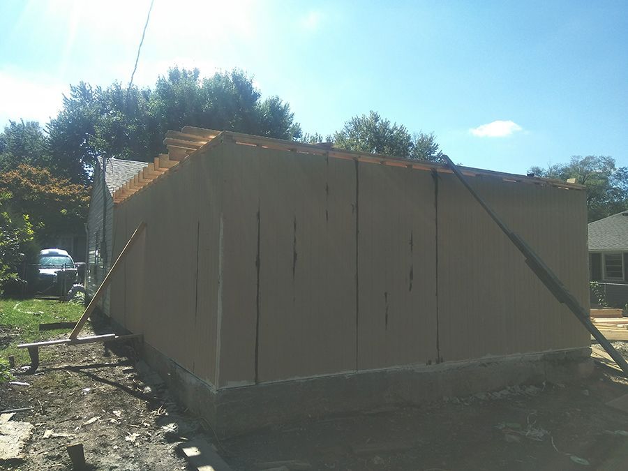 A shed is being built in the backyard of a house.