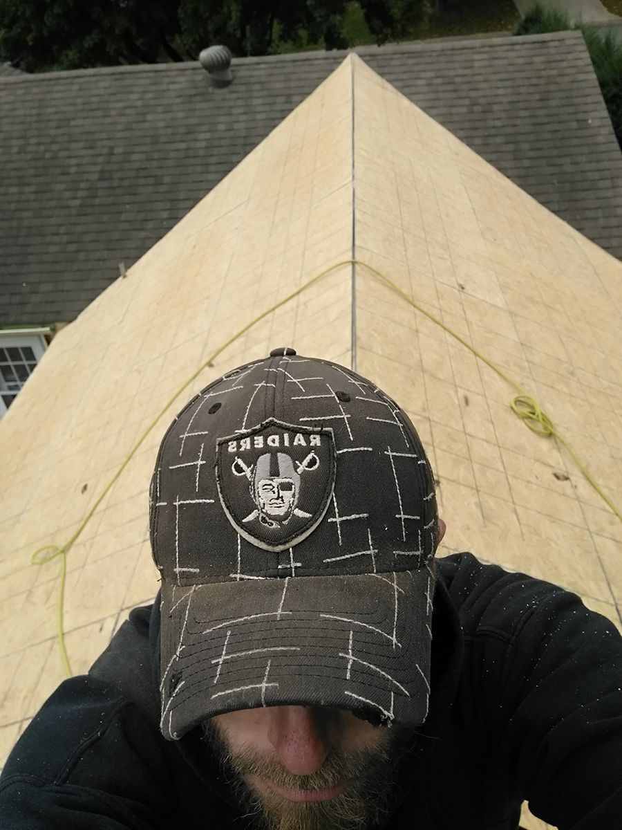 A man wearing a hat that says raiders on it.