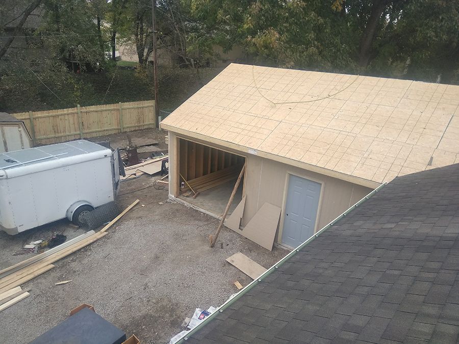 An aerial view of a garage under construction with a trailer in the background.
