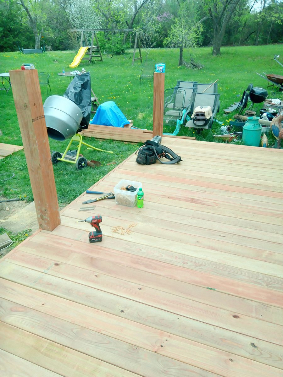 A wooden deck is being built in a backyard.