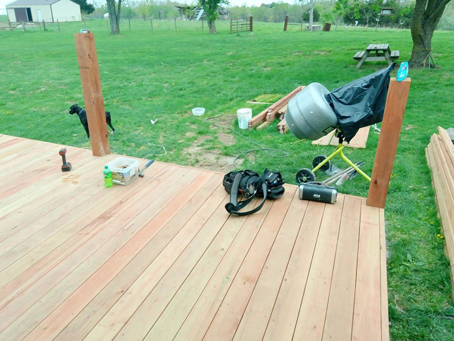 A wooden deck is being built in a grassy field.