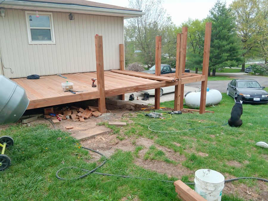 A wooden deck is being built in front of a house.