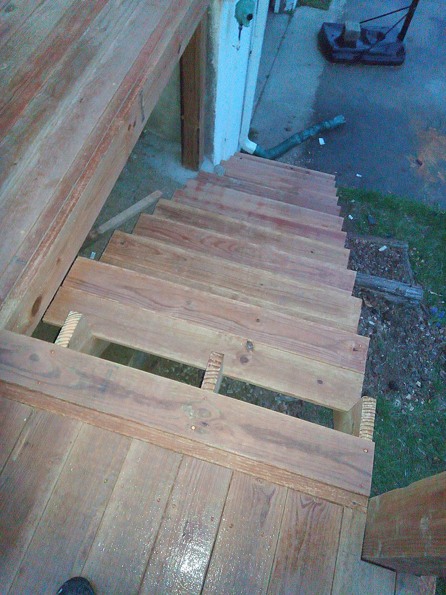 A wooden staircase is being built on top of a wooden deck.