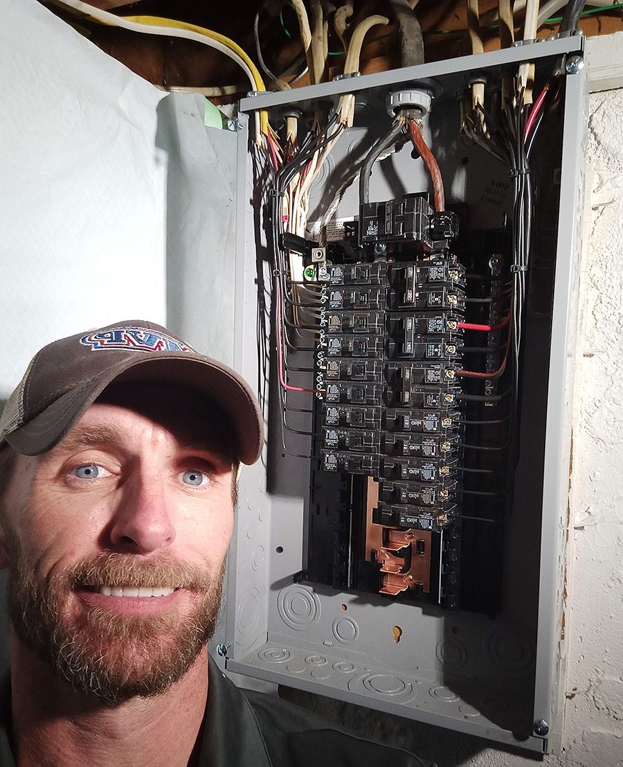 A man with a beard is standing in front of an electrical box.