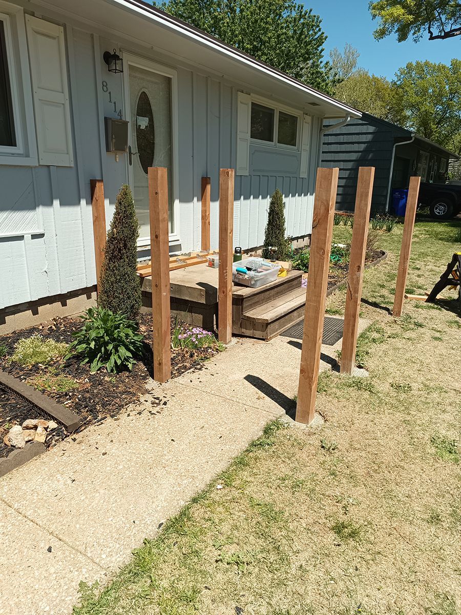 A wooden fence is being built in front of a house.