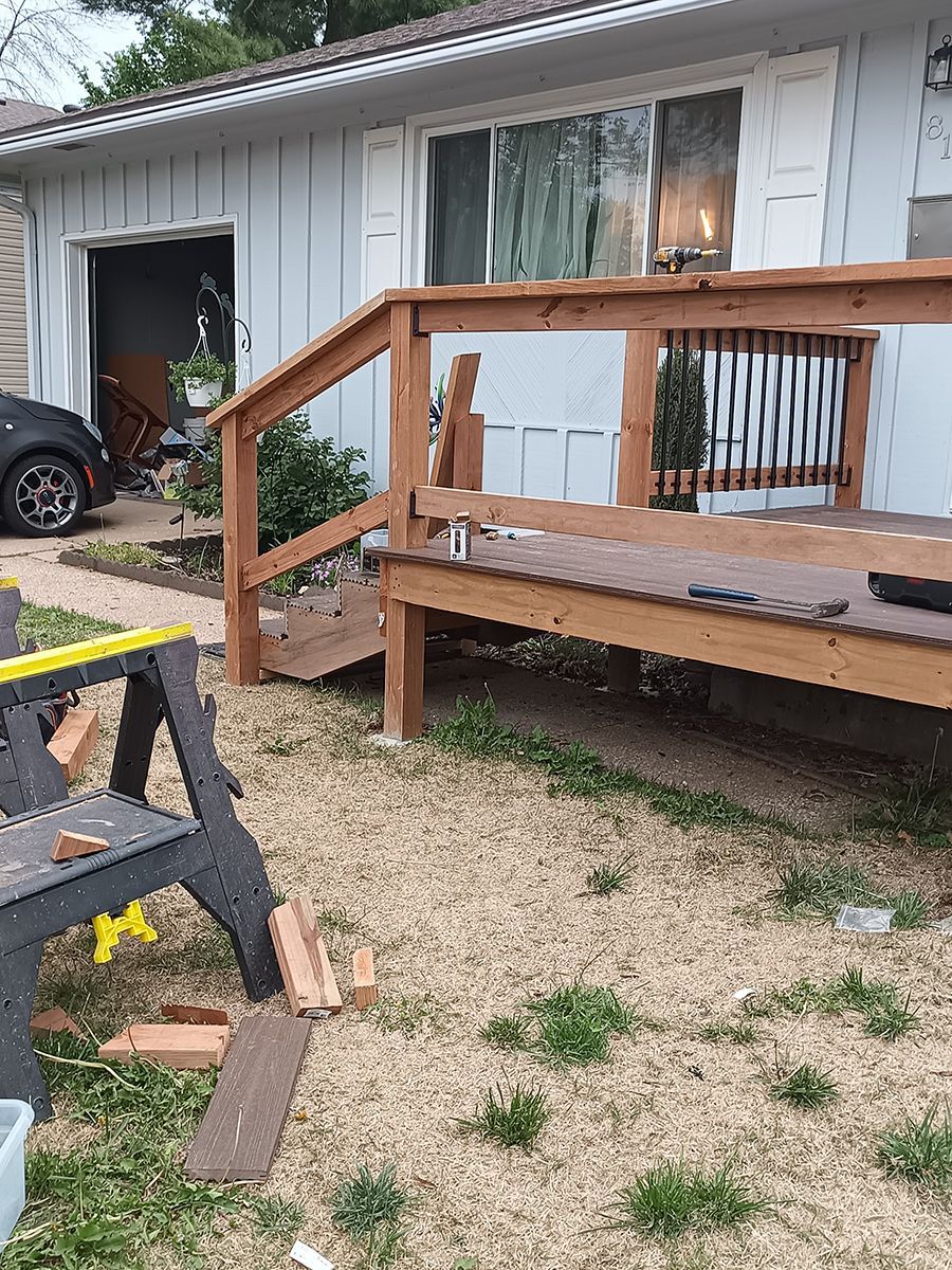 A wooden deck is being built in front of a house.
