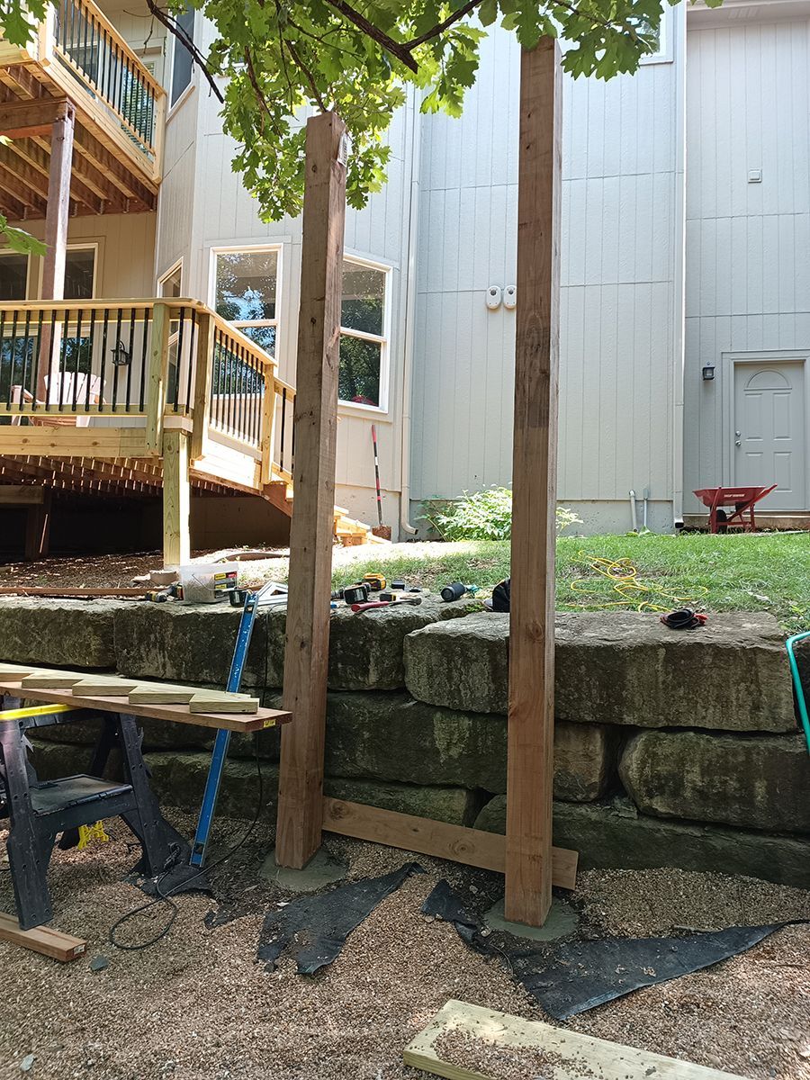 A wooden fence is being built in front of a house.