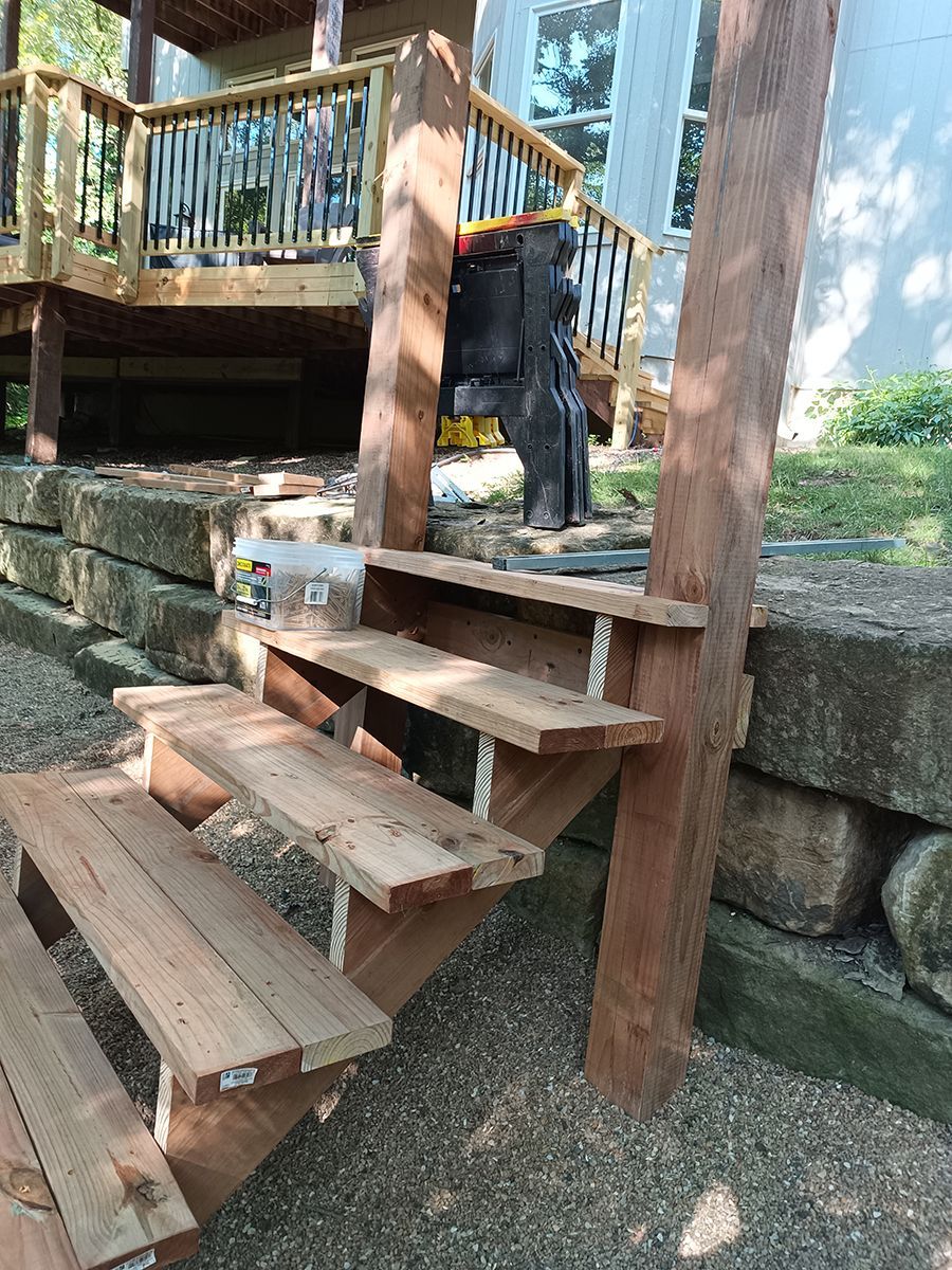 A set of wooden stairs leading up to a deck.