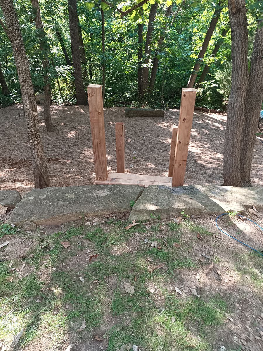 There is a wooden bridge in the middle of the woods.