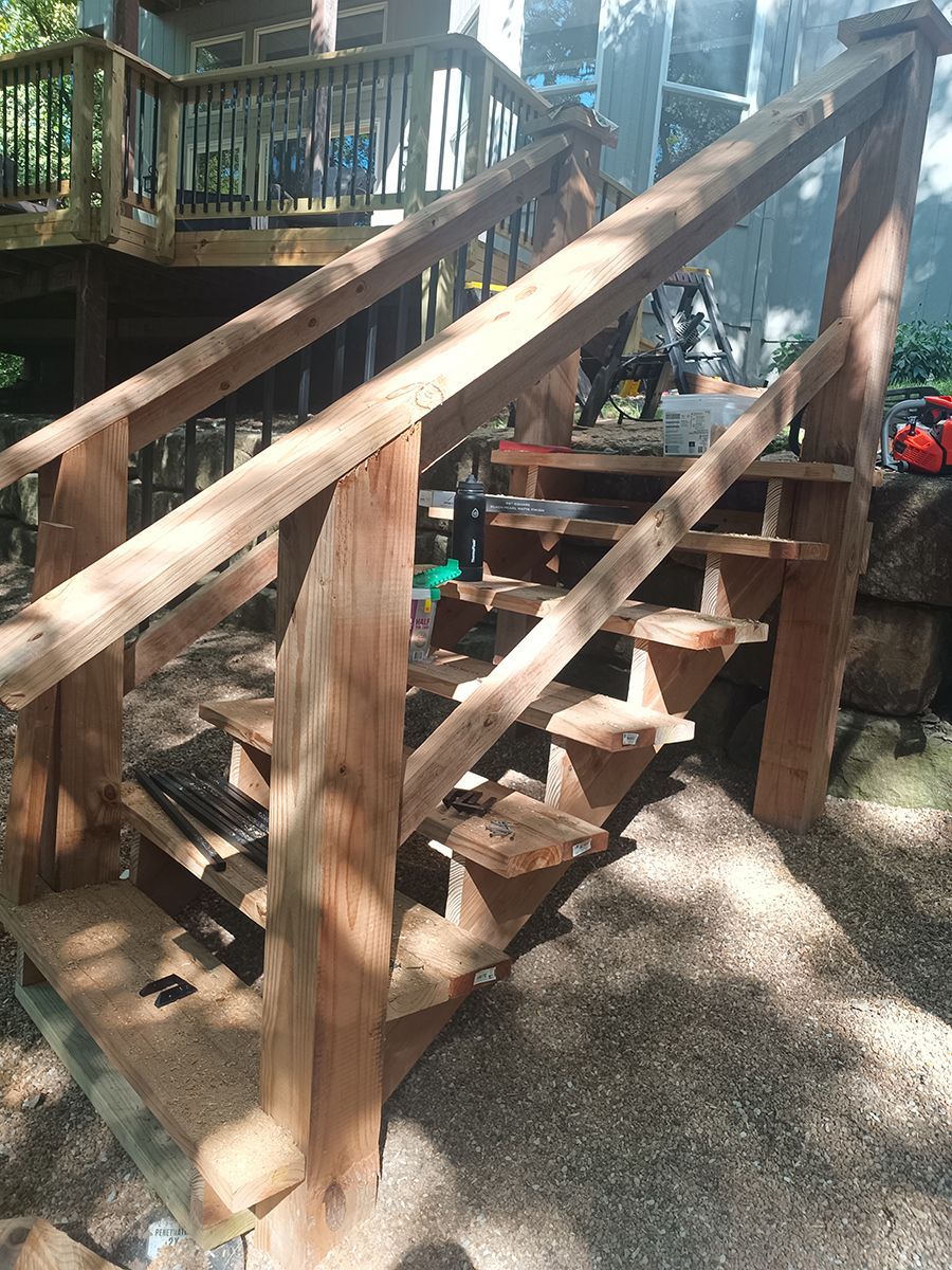 A set of wooden stairs leading up to a deck.