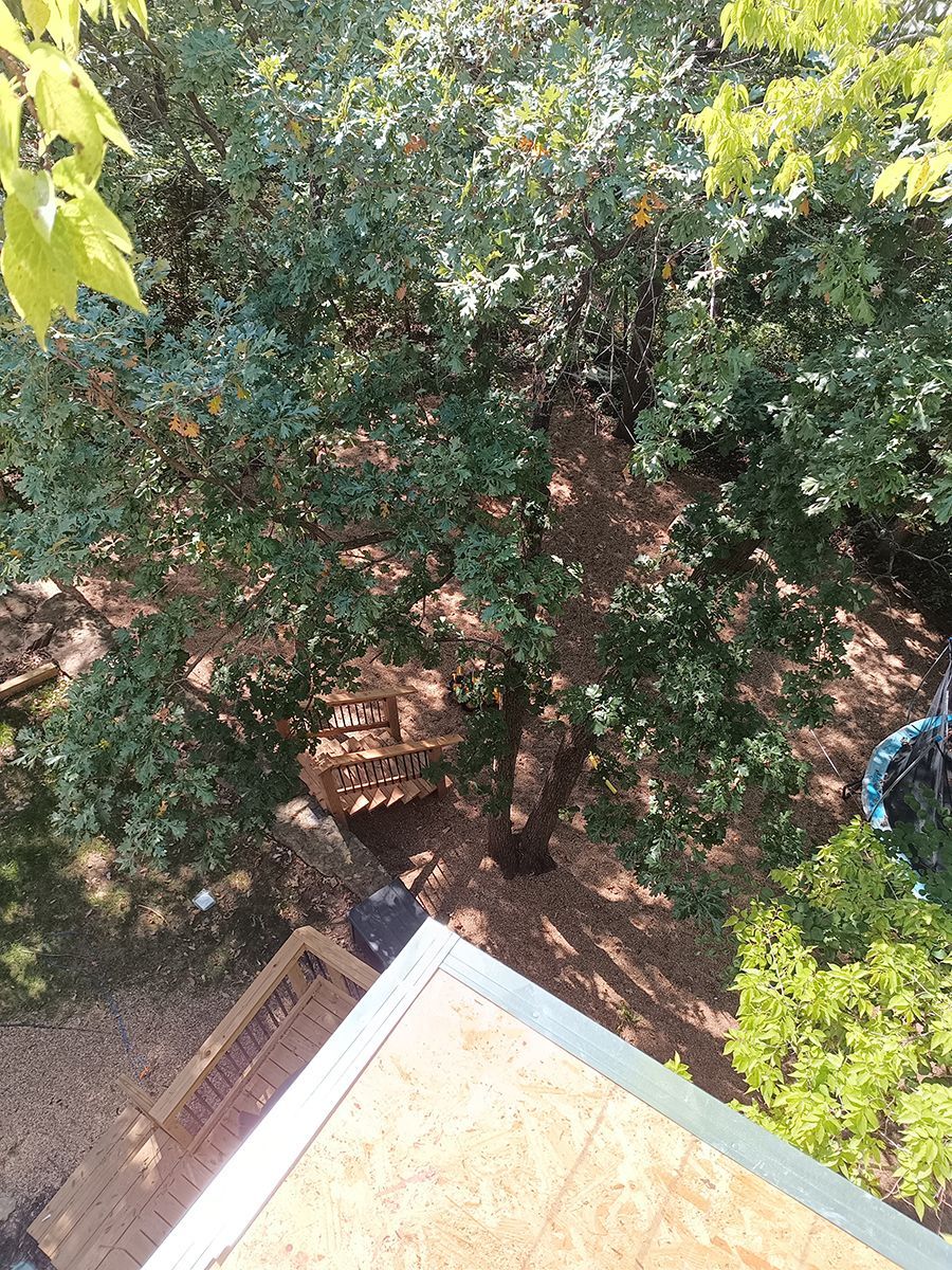 An aerial view of a roof with trees in the background.