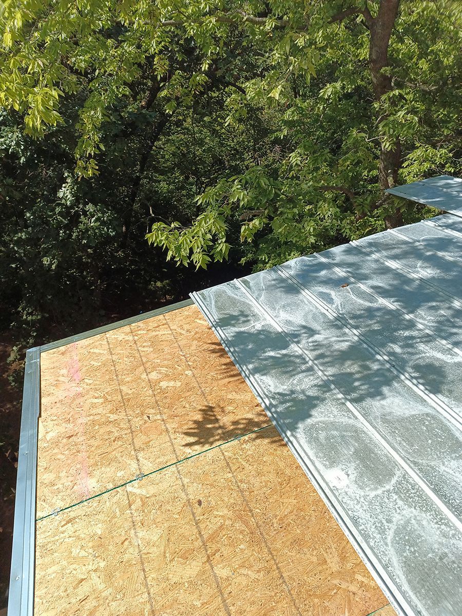 An aerial view of a roof with trees in the background.