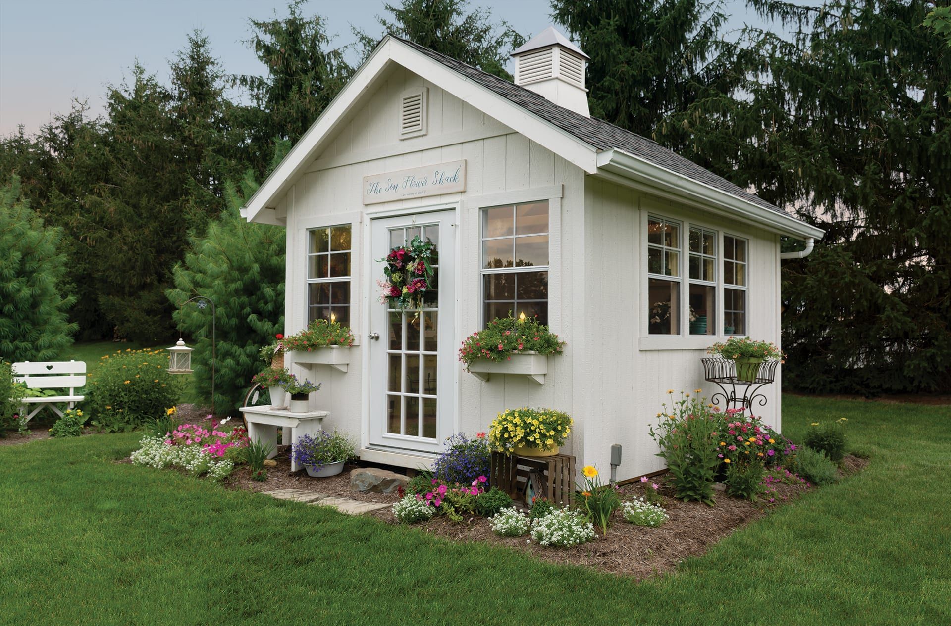 A white shed with flowers in front of it