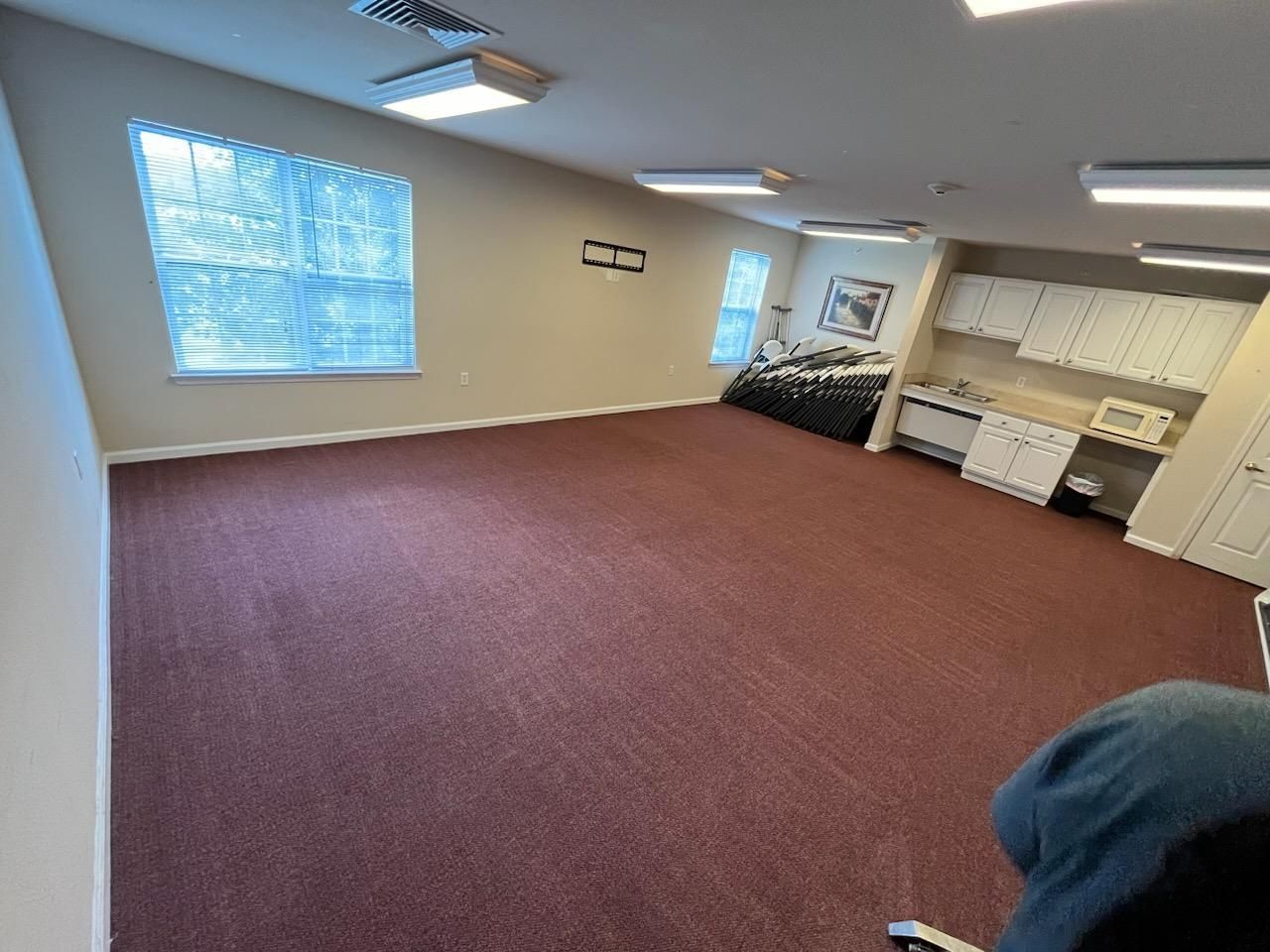 A large room with a red carpet and white cabinets.