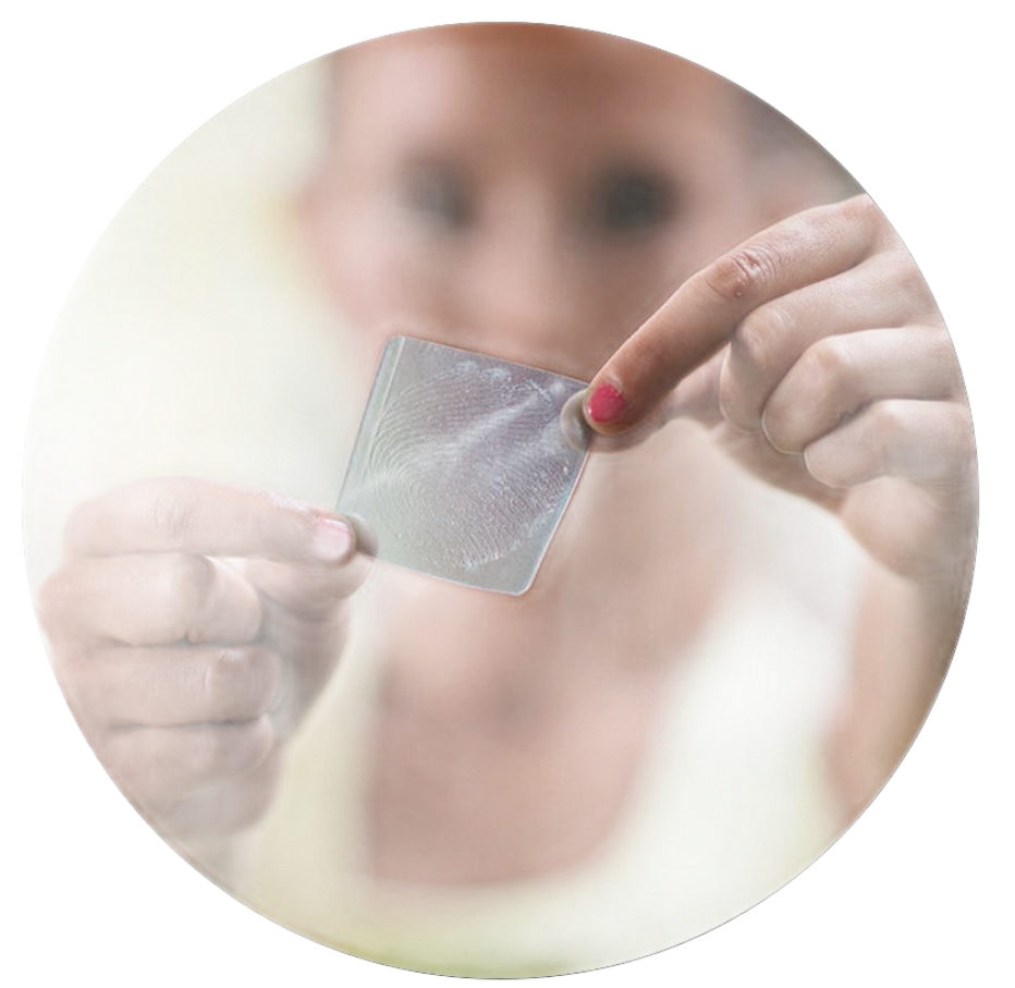 A person holds a small, clear, textured adhesive patch between their fingers against a blurred background.