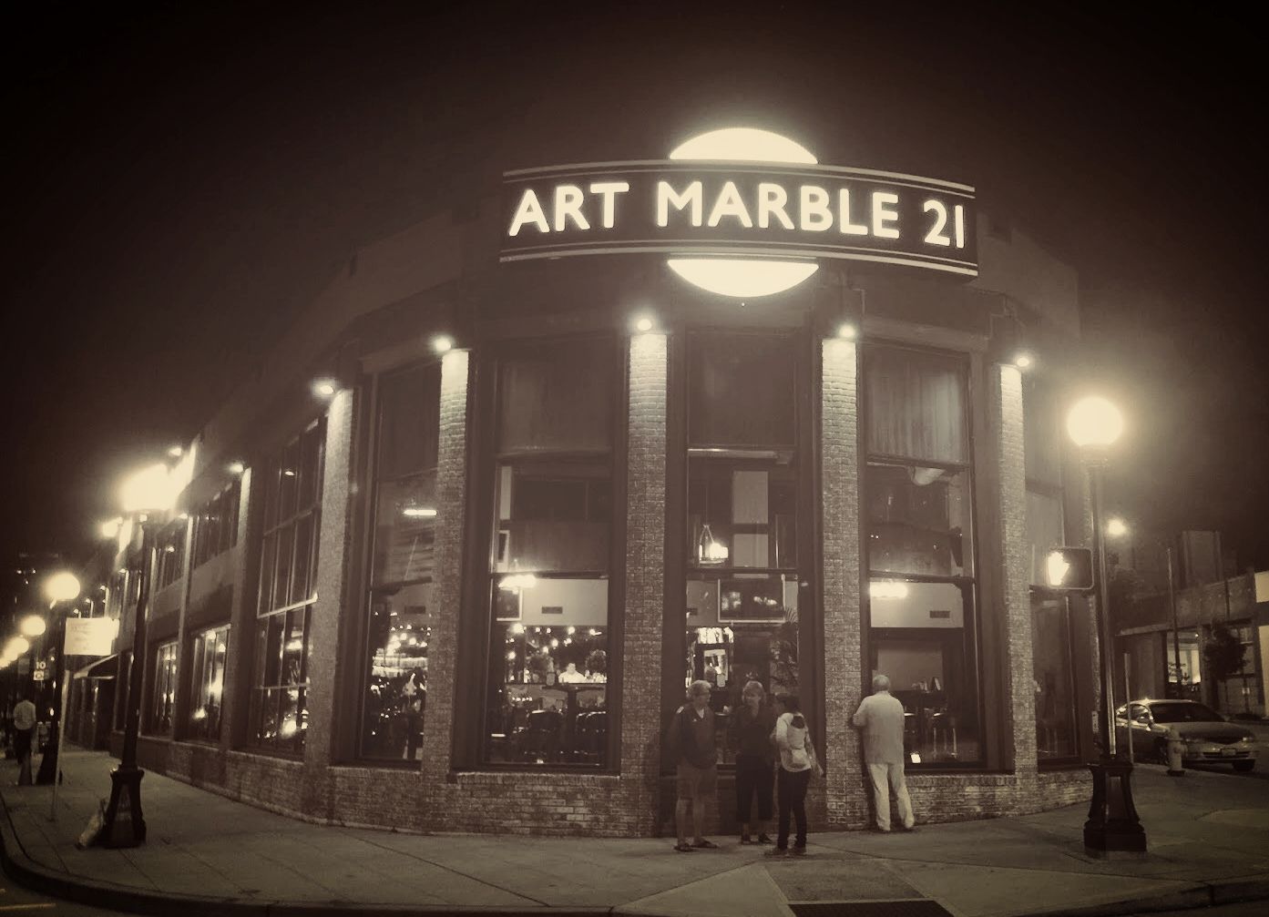 A black and white photo of art marble 21 at night