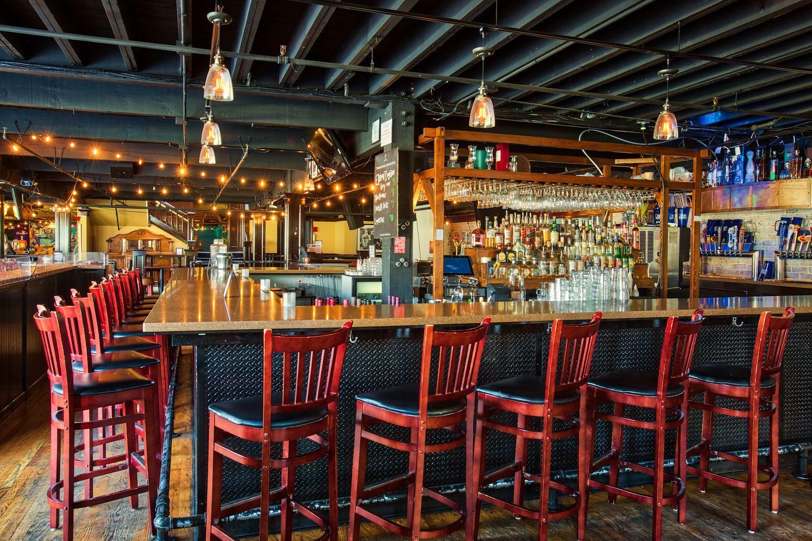 A restaurant with a long bar and lots of chairs