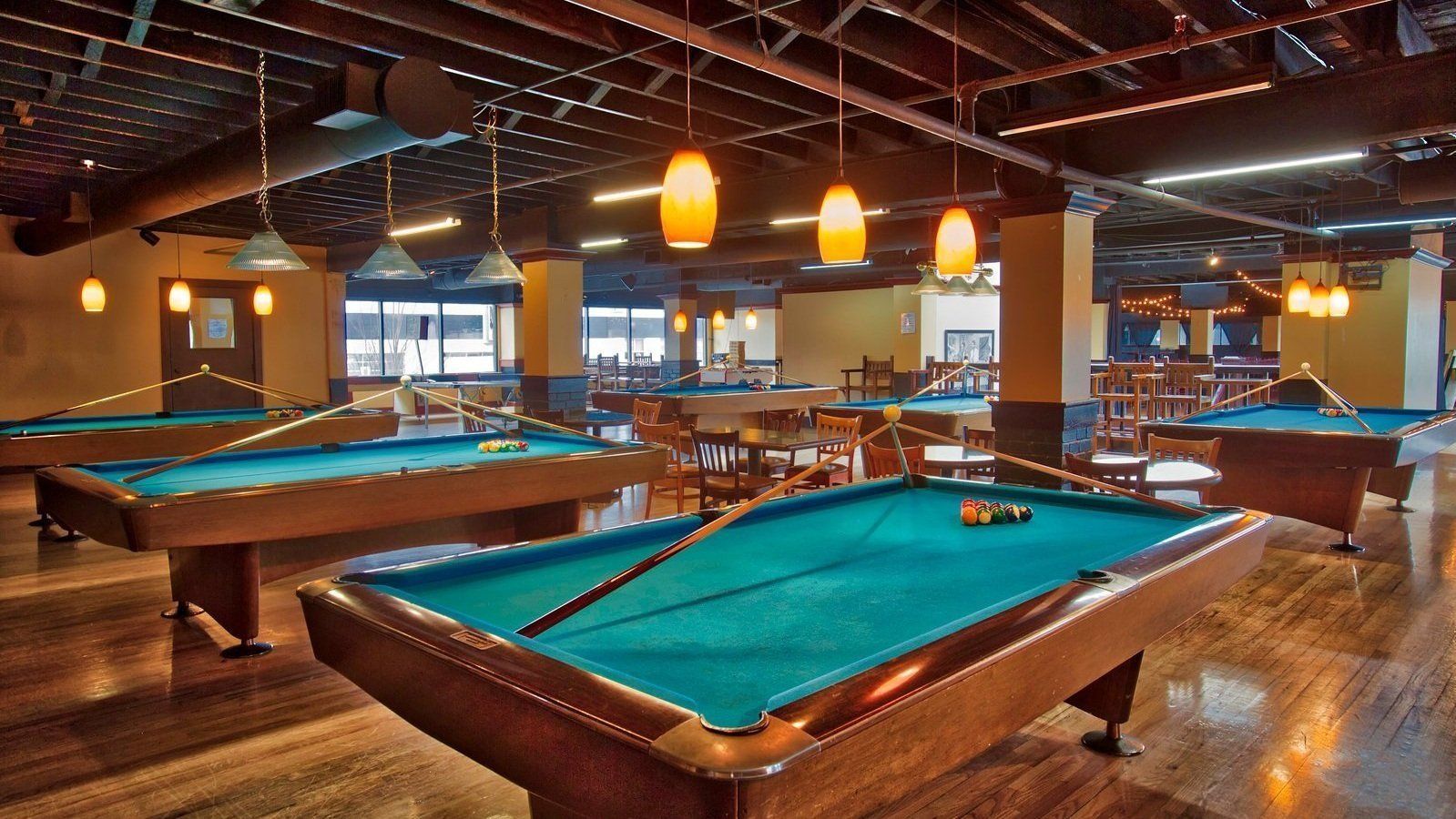 A pool hall with a lot of pool tables