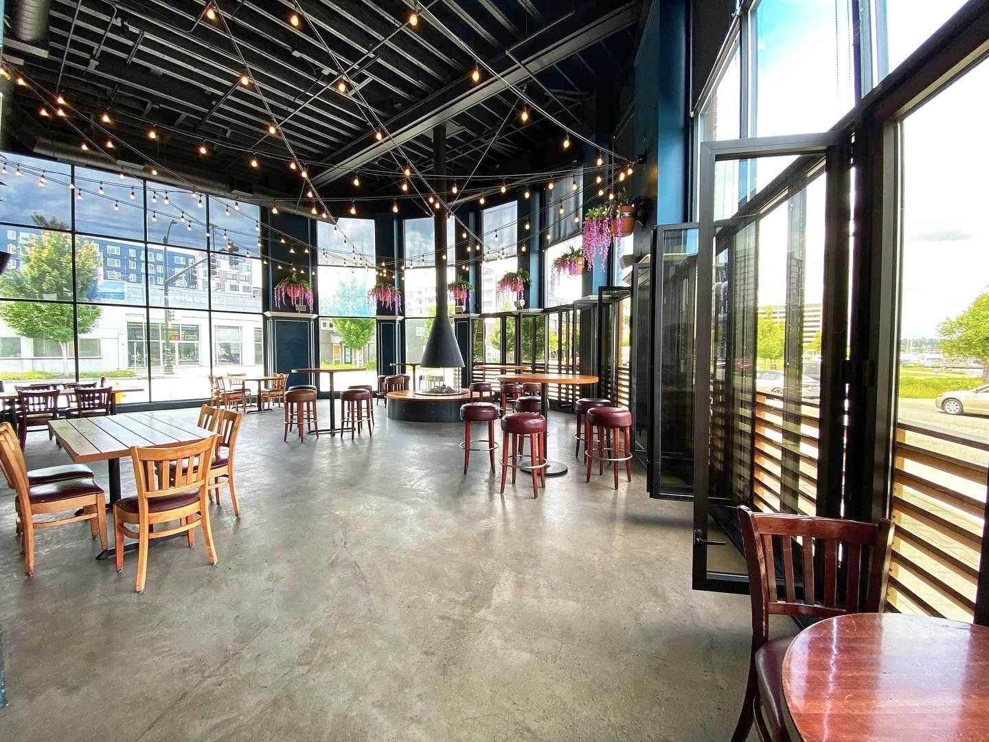 A restaurant with tables and chairs and a lot of windows.