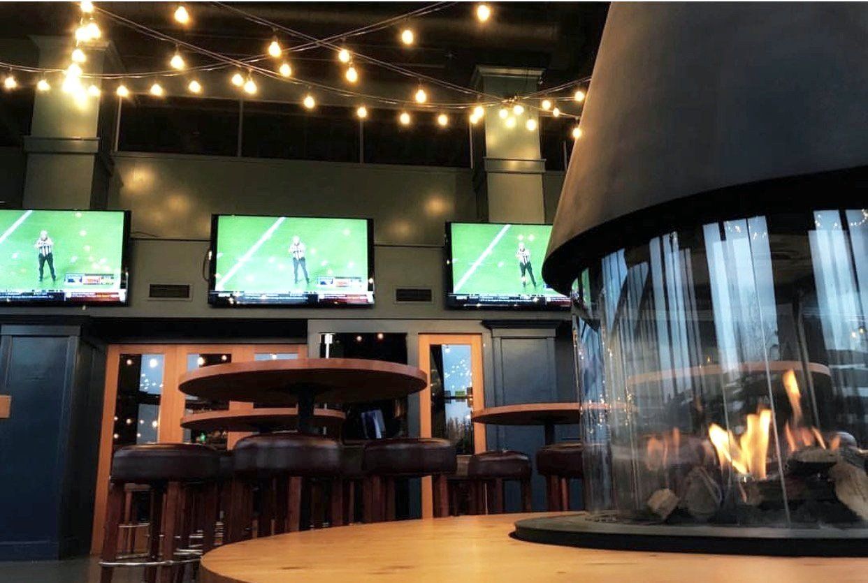 A fireplace in a room with a lot of televisions