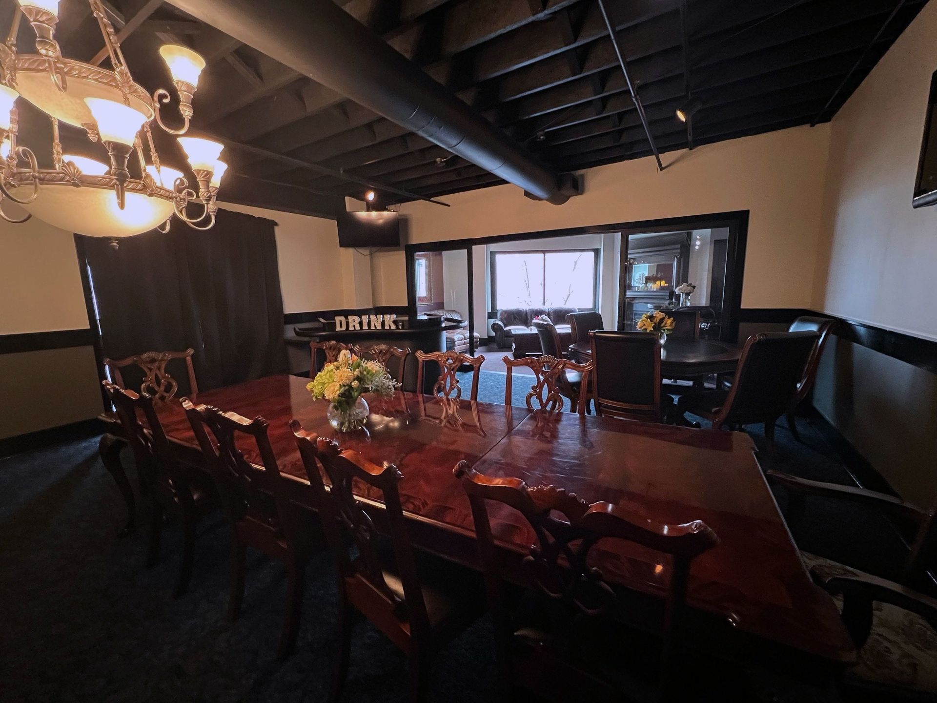 A room with a long table and chairs and a chandelier
