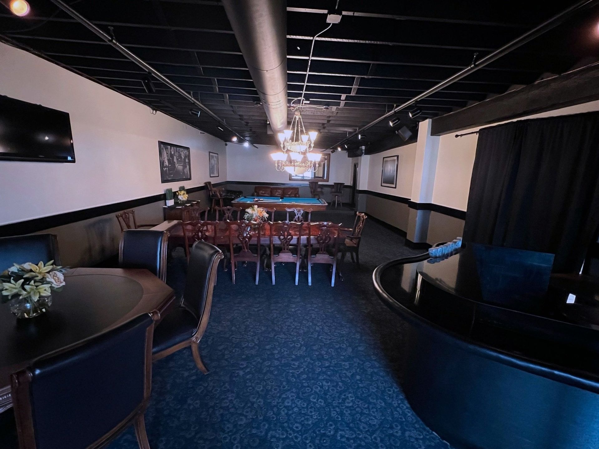 A large room with tables and chairs and a pool table
