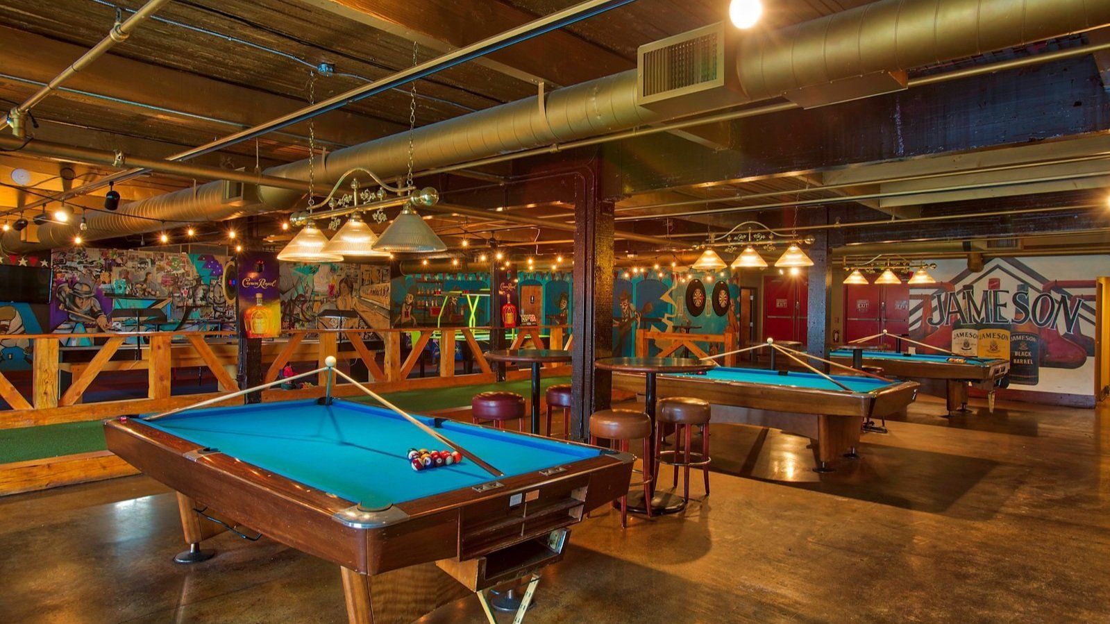 A pool hall with a lot of pool tables in it