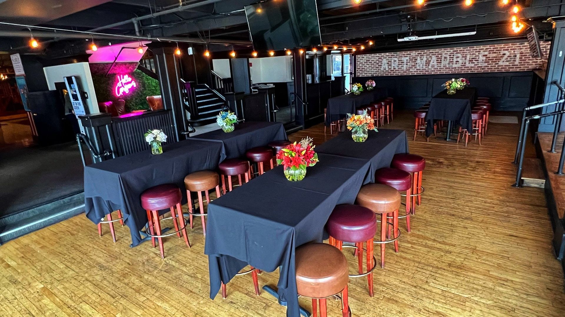 A large room with tables and stools set up for a party.