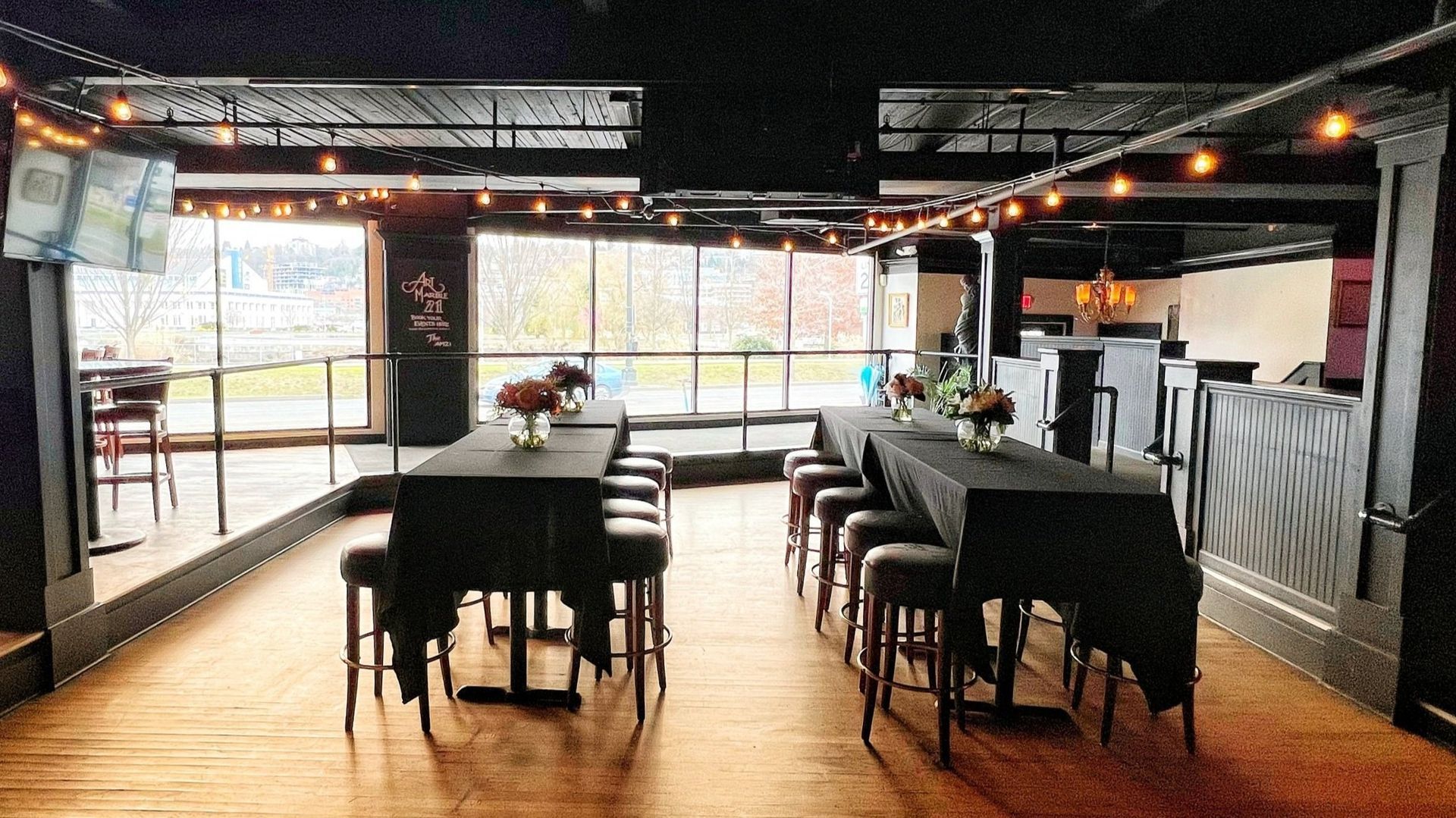 A large room with tables and stools in it.