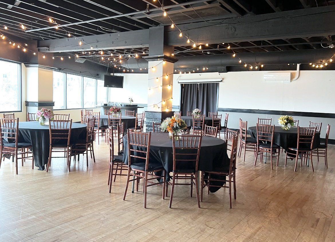 A large room with tables and chairs set up for a party