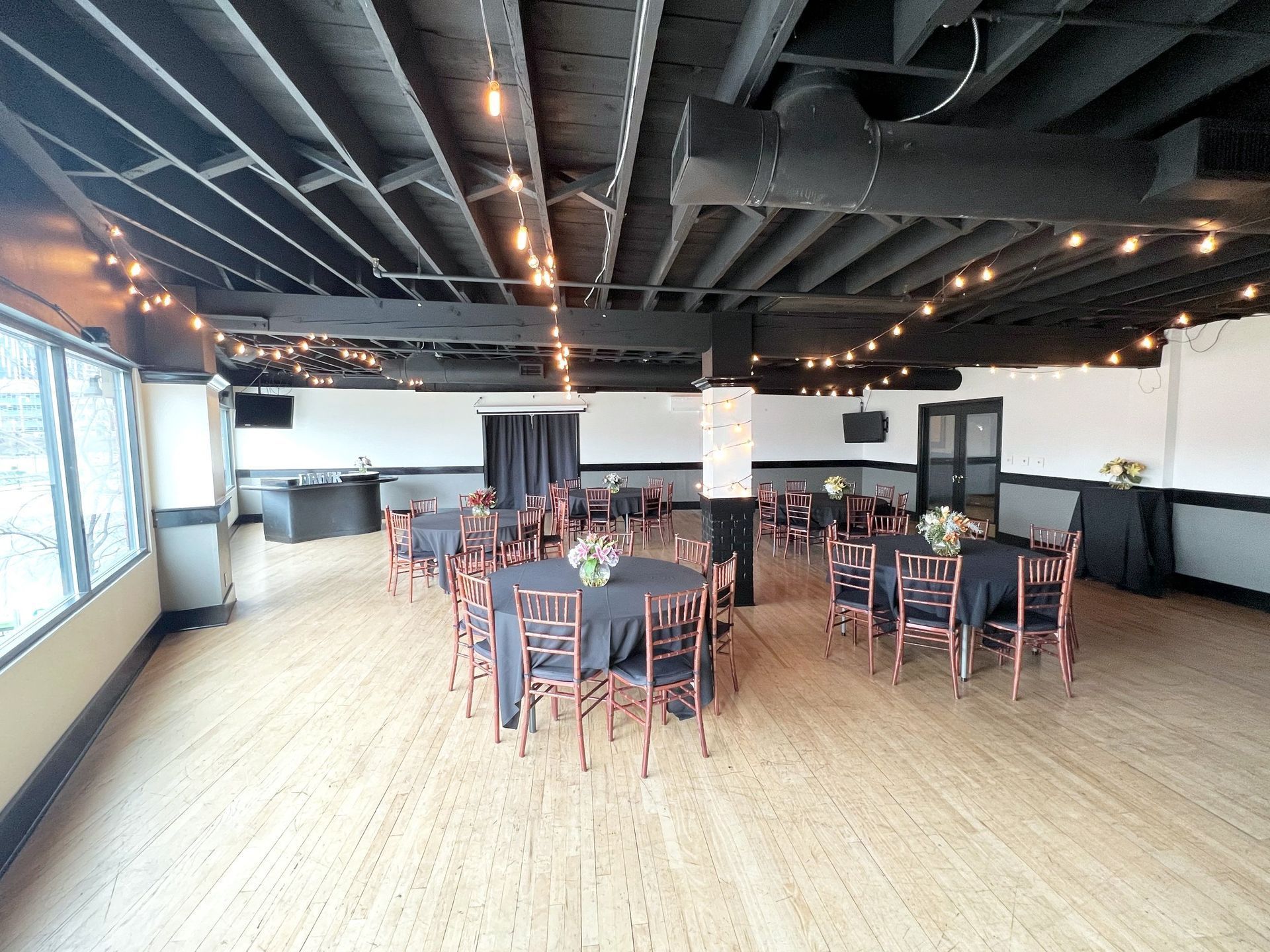 A large room with tables and chairs set up for a party.