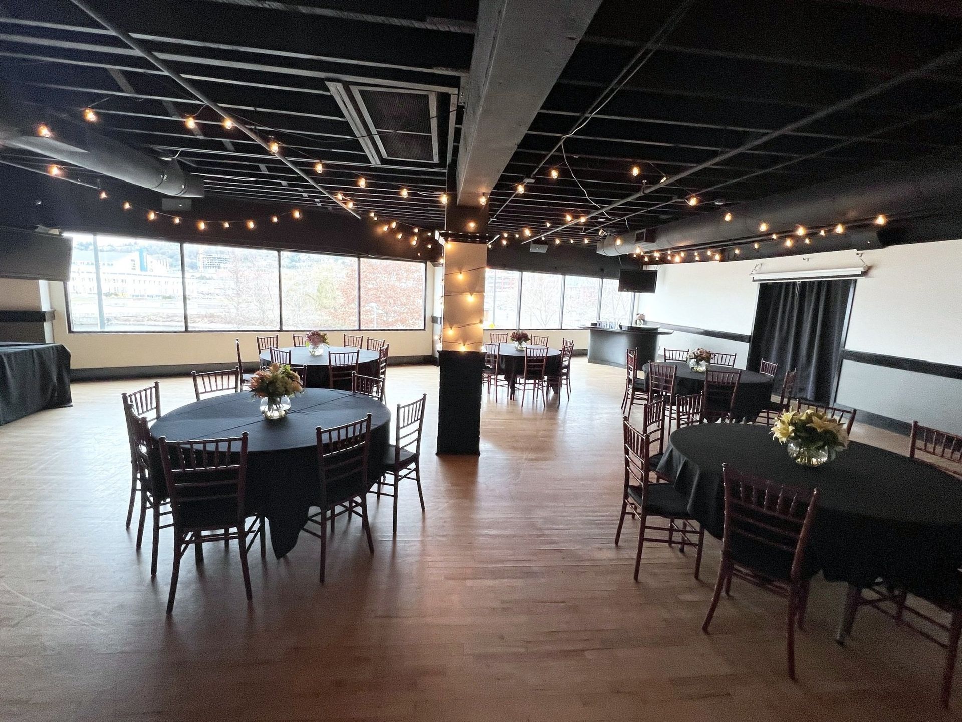 A large room with tables and chairs set up for a party