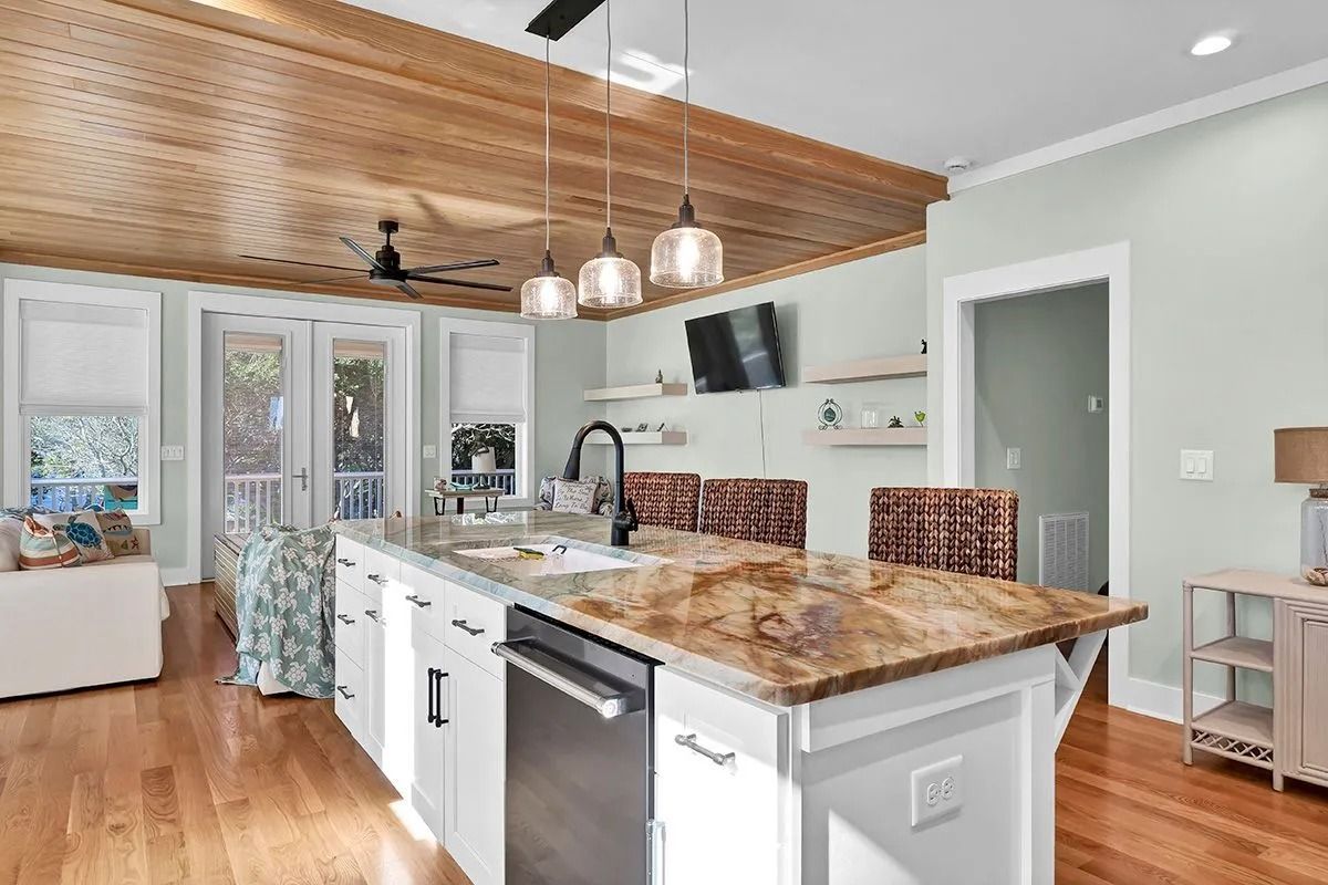 Kitchen with wood ceiling, island with granite countertop, and stainless steel appliances.