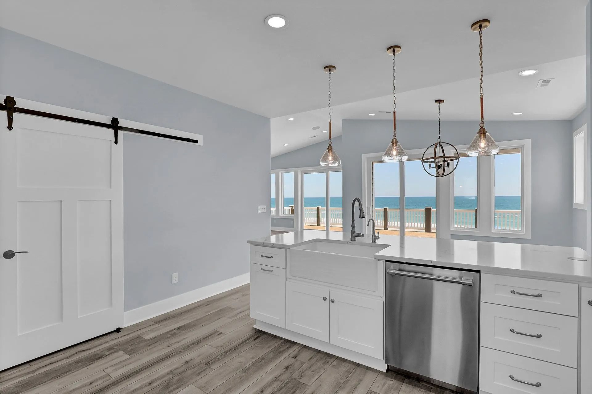 Coastal kitchen with white cabinets, stainless steel appliances, and ocean view.