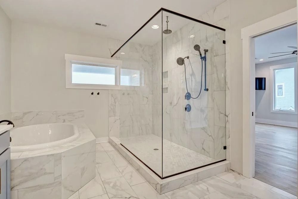 Luxurious bathroom with marble tile and large glass shower enclosure.