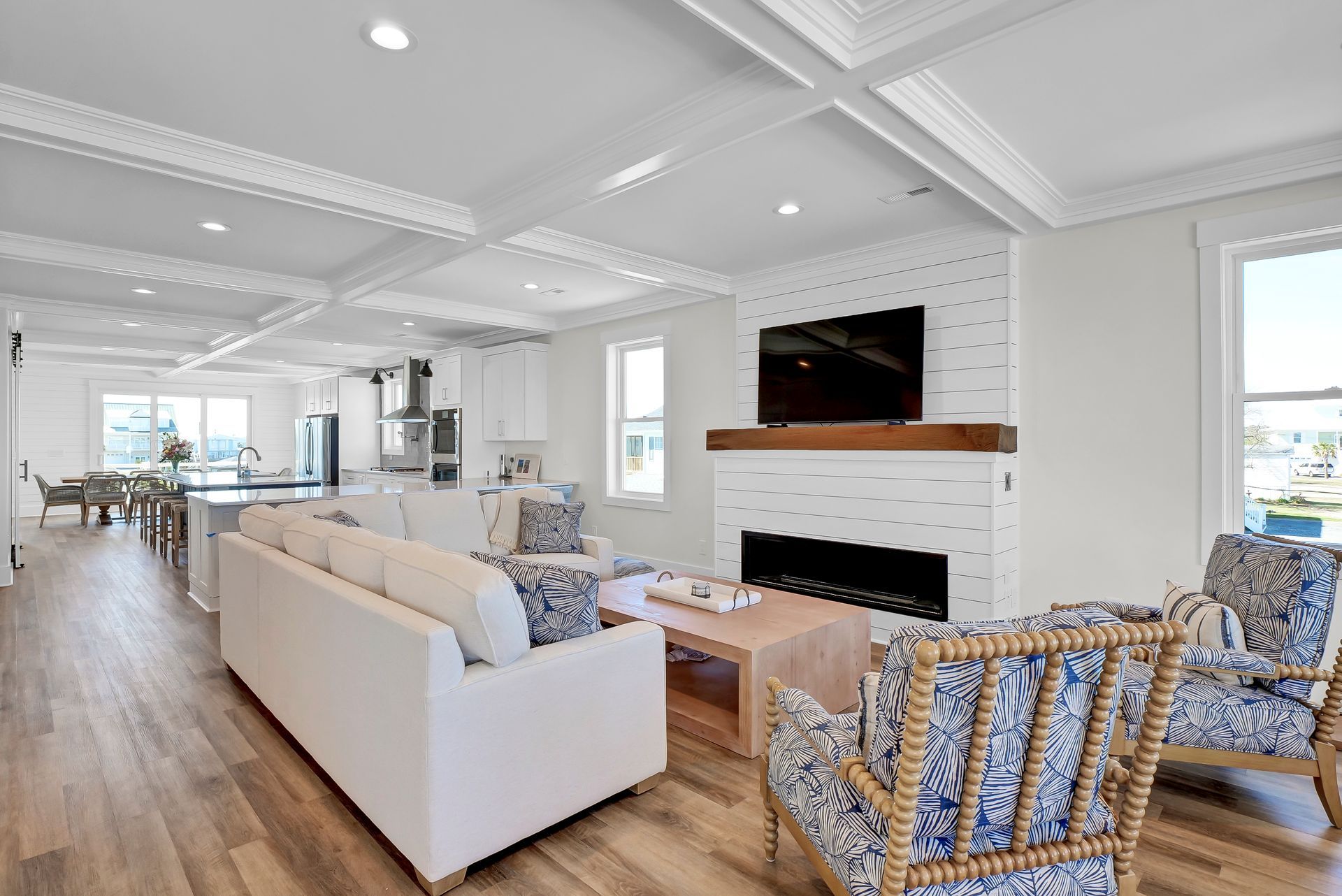 Spacious, bright living room with white walls, a fireplace, and comfortable seating.
