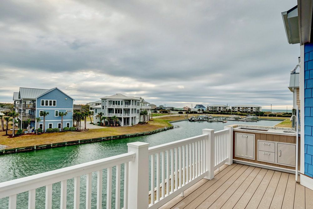 Balcony overlooking a waterway lined with houses on a cloudy day.