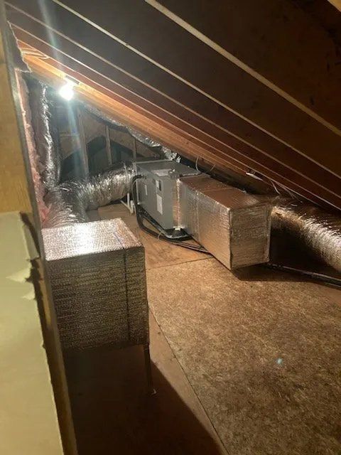 A room with a lot of ducts coming out of the ceiling.