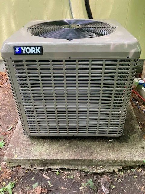 A york air conditioner is sitting on a concrete surface.
