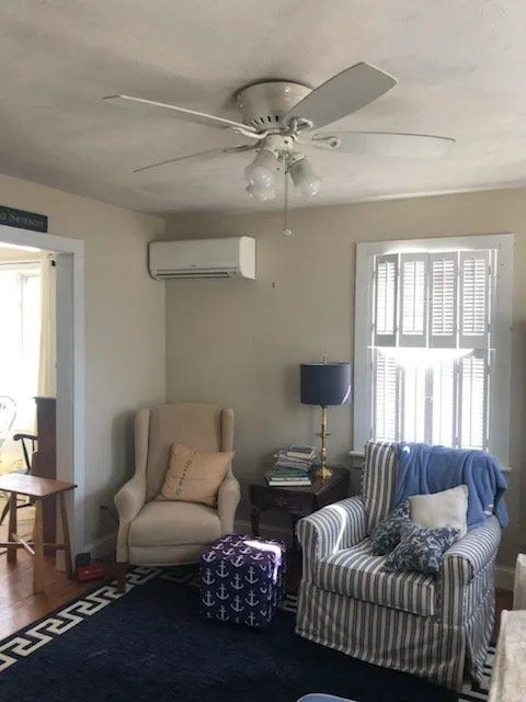 A living room with two chairs and a ceiling fan