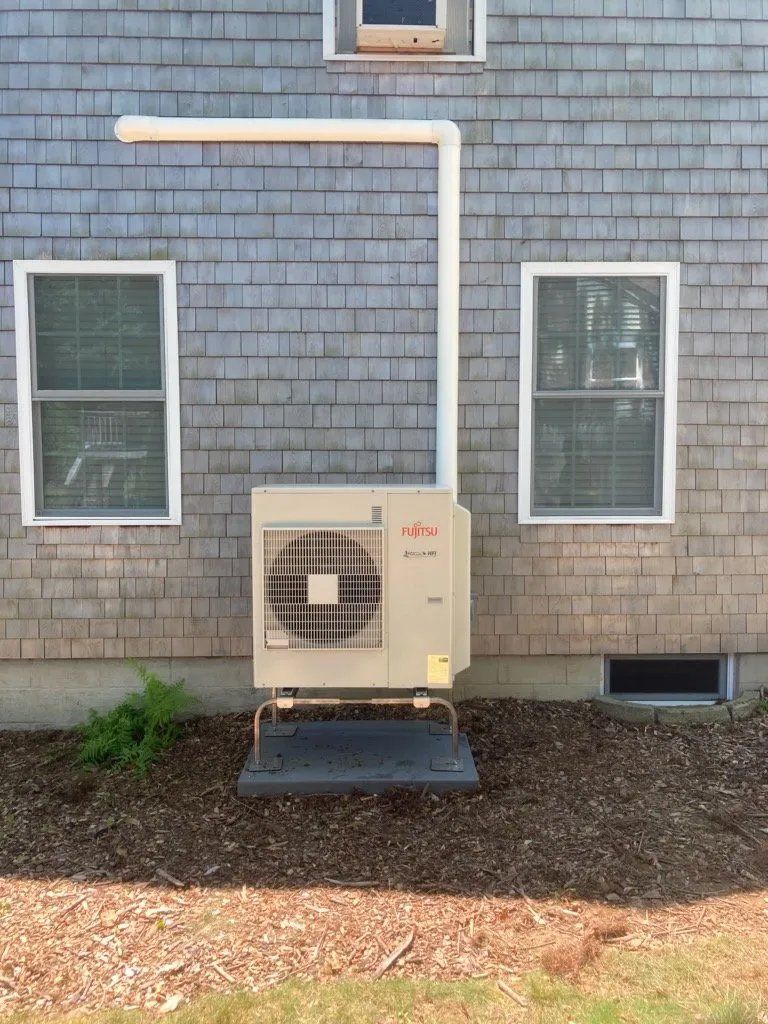 An air conditioner is installed on the side of a house.