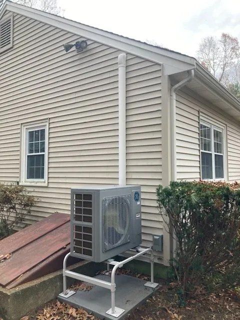 An air conditioner is mounted on the side of a house