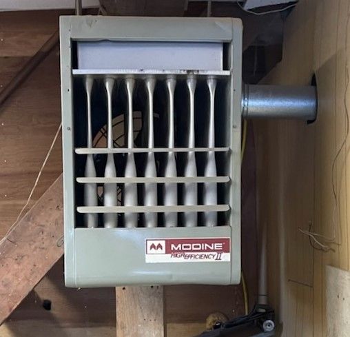 A modine heater is mounted to a wall